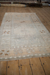 Low angle perspective of a vintage Oushak rug with a soft, distressed patina.