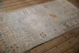 Lengthwise view of a vintage distressed Oushak rug highlighting its soft, low pile and silver geometric patterns.