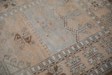 Time-softened texture of a distressed Oushak rug with silver and pale saffron motifs.