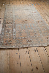 Long perspective view of the distressed vintage Oushak rug showing its low pile and soft texture.