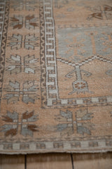 Detail of the vintage Oushak rug's geometric border in time-softened silver and dark copper.
