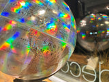 Rainbow light reflecting on holographic Central and South America regions of the globe.