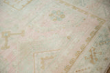The hand-knotted pile of a distressed Oushak showing even wear and soft colors.