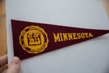 Gold University of Minnesota seal printed on vintage maroon felt pennant.
