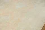 Soft, even pile of a distressed Oushak carpet showing lustrous, tone-on-tone tangerine and ivory hues.