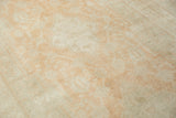 Soft, even-piled wool texture of a distressed Oushak in pale tangerine and sandalwood.