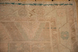 Evenly worn pile on a distressed Oushak rug showing hand-knotted texture and a turquoise border.