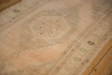 Stepped medallion and abrashed field on a distressed Oushak runner in soft sand and pale apricot.