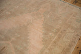 Stepped turquoise contours on the abrashed apricot and sand field of a distressed Oushak rug.