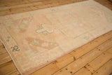 Angled perspective on a vintage Oushak runner showing the low-pile texture and turquoise corner accents.