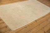 Angled view of a distressed Oushak runner showing the even wear and pale dusty rose field.