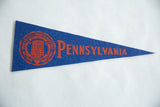 Orange university crest on the blue felt of a vintage Pennsylvania pennant.