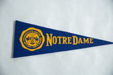 Notre Dame school crest in yellow on blue vintage felt pennant.