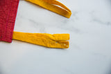 Worn yellow felt ties with small holes and fraying on the vintage North Carolina banner.