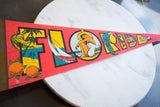 Colorful parrot, marlin, and beach scene detail on the vintage Florida felt flag.