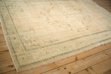 Vintage distressed Oushak carpet showing faded mint green borders and cream field.