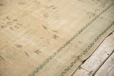 Distressed Oushak carpet detail, showing worn pile, subtle ivory, cream, and mint motifs.