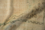 Close-up of distressed Oushak rug texture, revealing even wear, faint foundation, and muted vinery.