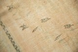 Close-up of distressed vintage Oushak pile, showing wear and faint green, brown tones.