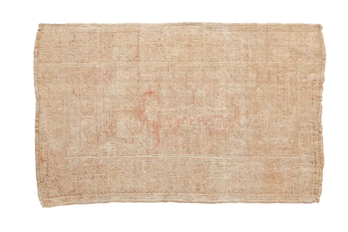 Vintage distressed Melas rug with a heavily worn geometric floral design in pale ivory and dusty rose.