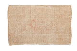 Vintage distressed Melas rug with a heavily worn geometric floral design in pale ivory and dusty rose.