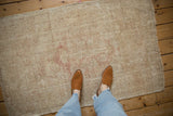 Overhead view of a vintage distressed Melas rug, showing its scale and time-softened texture.