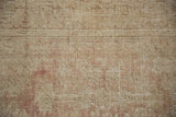 Close-up of the distressed low pile showing knot heads and foundation on a vintage Melas rug.