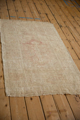 Distressed vintage Melas rug viewed lengthwise, highlighting its faded ivory and dusty rose hues.