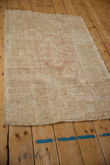Angled view of the distressed vintage Melas rug, highlighting its overall faded pattern and worn texture.