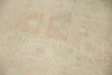 Evenly worn, distressed Oushak carpet pile with faded pale pink and sea foam green tones.