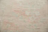 Distressed Oushak carpet pile texture with even wear and faded pale pink, sea foam green hues.