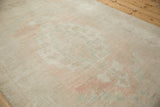 Distressed Oushak rug detail: abrashed pile with even wear, faded pink and sea foam green.