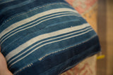 Vintage African textile pillow with varying indigo shades and visible hand-stitched strips.