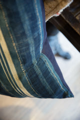 Textured detail of the indigo African textile pillow with woven stripes and visible seam stitching.