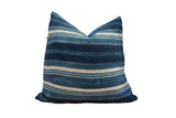Indigo African Textile Throw Pillow showcasing varied blue and cream stripes with visible stitching, 20x20.