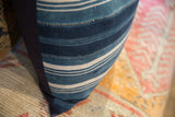 Close-up of the vintage indigo striped African textile pillow showing texture and navy backing.