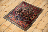 Angled view of a vintage Farahan Sarouk rug showing its intricate pattern and time-softened edges.