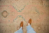 Aqua blue scalloped medallions on the dusty rose and beige field of a distressed Oushak runner.