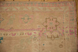 Evenly worn pile on a vintage Oushak rug with blush, beige, and aqua floral motifs.