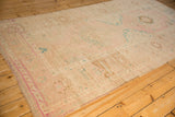 Lengthwise view of the vintage Oushak runner's splayed medallions and time-softened colors.