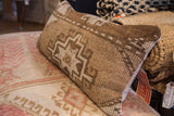 Detailed view of vintage Turkish rug pillow, showcasing robust hand-knotted brown geometric motifs.