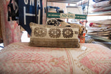Textured vintage pillow featuring hand-knotted brown and cream medallion motifs.