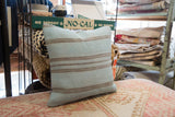 Vintage rug fragment pillow with pale blue and taupe horizontal stripes, flatwoven texture.