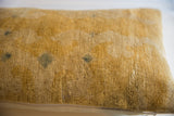 Aged gold texture with historic patina on the antique Chinese rug fragment pillow.