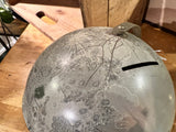 Vintage 1970s Moon globe piggy bank, showing the coin slot, metal loop, and lunar surface marks.