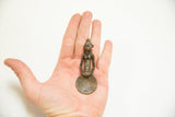 Vintage African bronze gold weight spoon held in a hand to demonstrate scale.