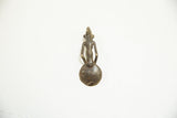 The back of a cast bronze Ashanti spoon, highlighting the aged patina and stylized form.