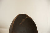 Vintage African bowl showing a textured repair and crack along the dark wooden rim.