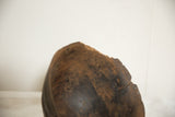 The aged, chipped rim and dark, hand-carved texture of a vintage African bowl.