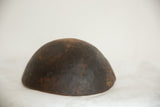 Underside view of the vintage wooden bowl showing its dark aged patina.